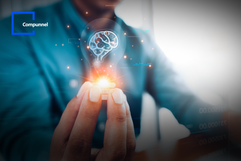 This image features a person in a blue shirt holding a lightbulb between their fingers, with the bulb illuminated and superimposed with a graphic of a glowing brain. The brain appears to be a symbol of an idea or innovation.