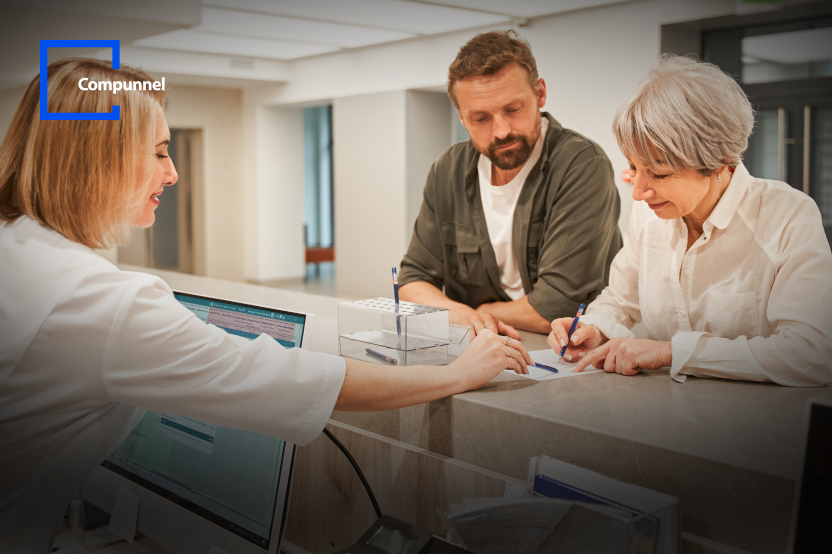 The image depicts a reception scene with a staff member assisting two clients as they fill out paperwork, with the Compunnel logo in the upper left corner.