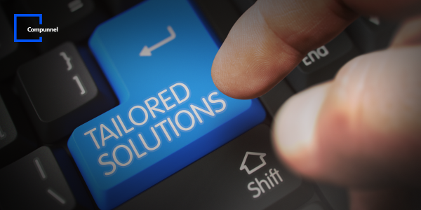 Finger pressing a blue key labeled 'TAILORED SOLUTIONS' on a keyboard, emphasizing customized digital services
